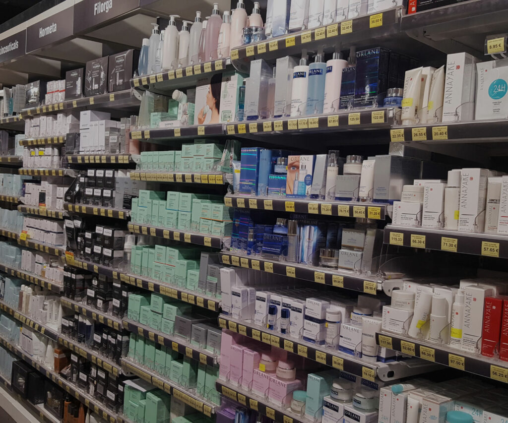 Rayon de parapharmacie avec des soins du visage et produits cosmétiques classés par marques